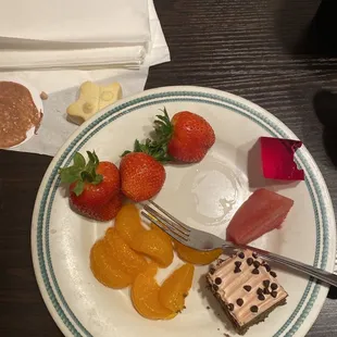 a plate of fruit and desserts