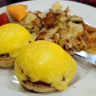 Eggs Benedict with hash browns, and fresh fruit