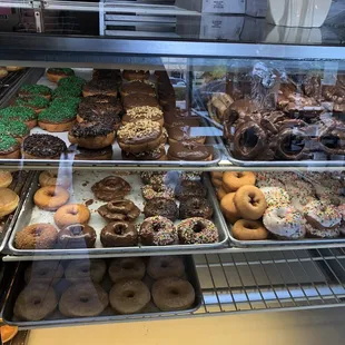a variety of doughnuts in a display case