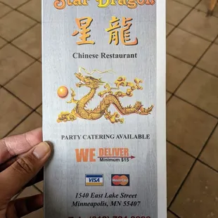 a hand holding a restaurant menu