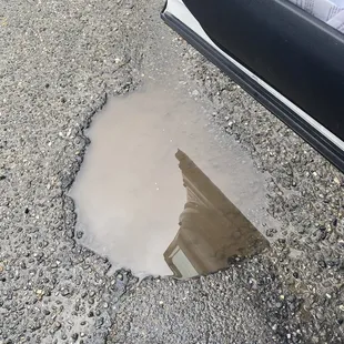 a puddle of water in a parking lot