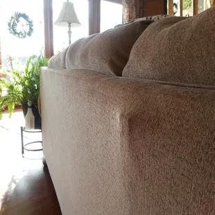 The frame beginning to push through the fabric at the back of one of the couches