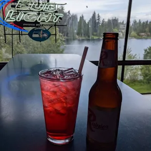 a glass of soda and a bottle on a table