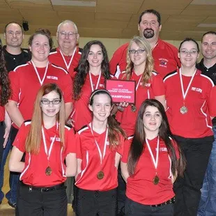 a group of people in red shirts posing for a picture