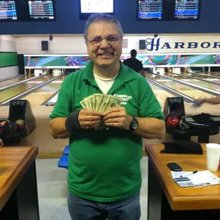 a man in a green shirt holding cash