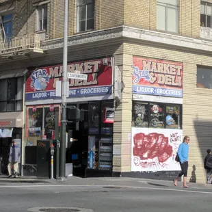 people walking on the sidewalk in front of a store