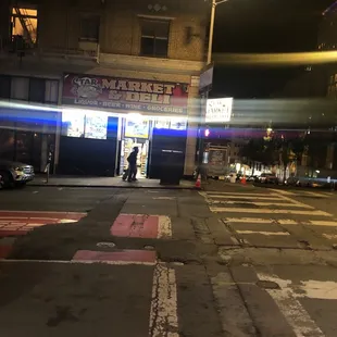 a man walking across the street at night