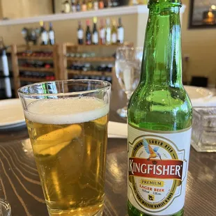 a glass of beer and a bottle of kingfisher