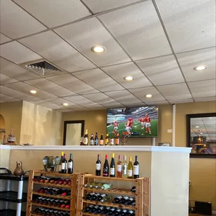 a bar with wine bottles and a television