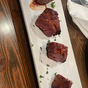 a plate of steak and a fork on a table