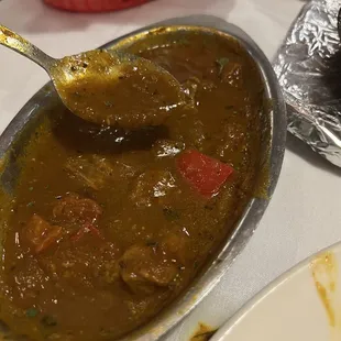 a bowl of curry with a spoon in it