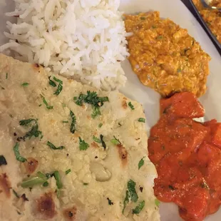 Clockwise: paneer bhurji, chicken makhani, garlic naan, and jeera rice