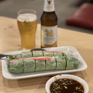 a plate of sushi rolls and a glass of beer