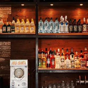 a shelf of liquor bottles and glasses
