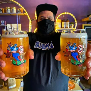 a man holding two glasses of beer