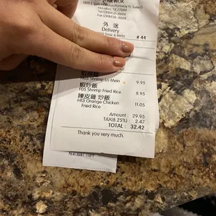 a person&apos;s hand holding a receipt