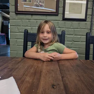 a little girl sitting at a table