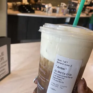 a hand holding a cup of iced coffee