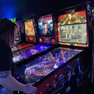 a woman playing a pinball game