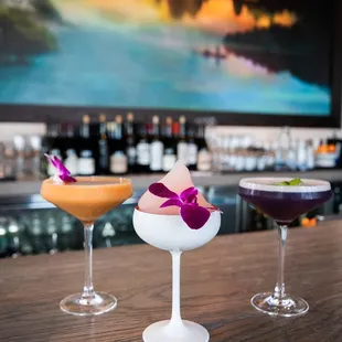 three cocktails on a bar