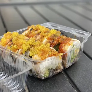 a plastic container filled with sushi