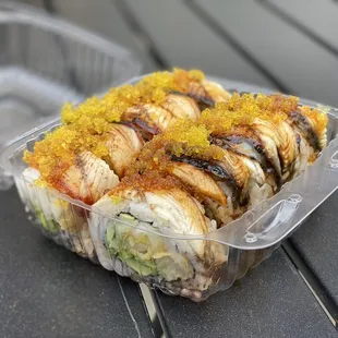 a plastic container of sushi