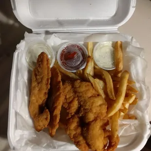 fried fish and fries in a styrofoam container