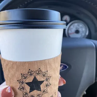 a hand holding a coffee cup