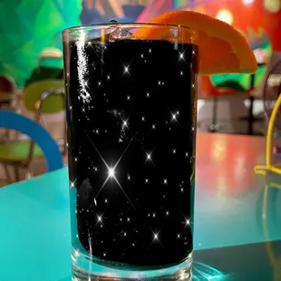 a glass of soda with an orange slice