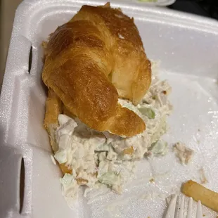 a croissant sandwich in a styrofoam container