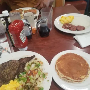 a breakfast of pancakes, eggs, hash browns, and sausage