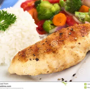 a chicken breast with rice and vegetables