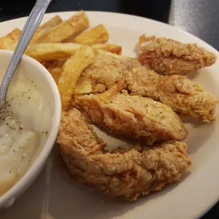 a plate of fried chicken, mashed potatoes, and gravy
