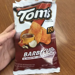 a hand holding a bag of chips