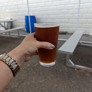 a hand holding a glass of beer