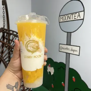a hand holding a cup of iced tea