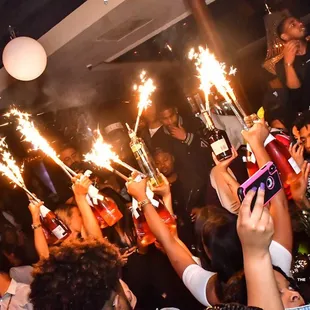 a group of people celebrating with sparklers