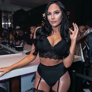 a woman in lingerie posing at a bar