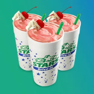 three drinks with strawberries on top