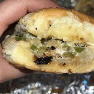 a hand holding a half eaten sandwich