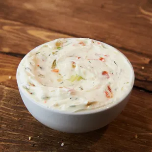 a bowl of dip on a wooden table