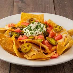 a plate of nachos on a wooden table