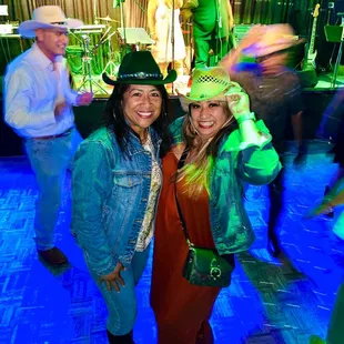 two women in cowboy hats at a party