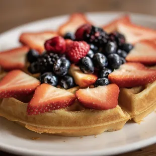 a waffle topped with strawberries and blueberries
