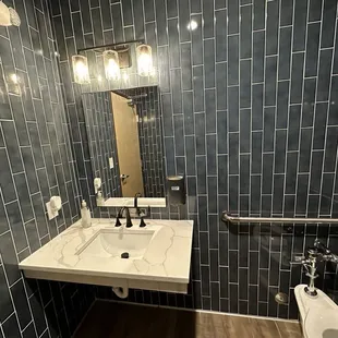 a bathroom with a toilet, sink, and mirror