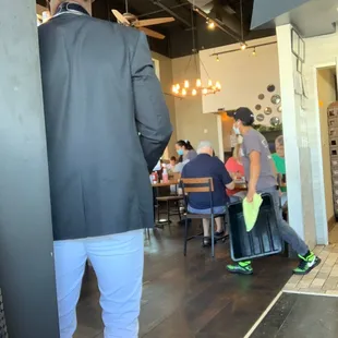 a man in a suit and hat standing in a restaurant