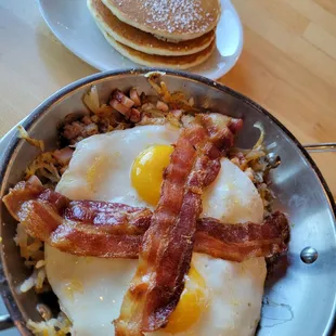 Whole hog skillet. Choice 2 eggs on ham, sausage, bacon, hashbrowns, and cheese, with a choice of biscuit, toast or pancakes.