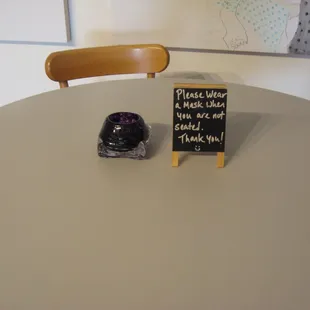 a table with a chalkboard sign and a cup of coffee