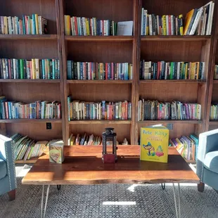 two blue chairs in front of a bookshelf
