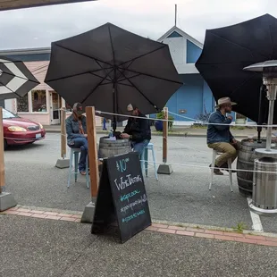 a group of people sitting under umbrellas